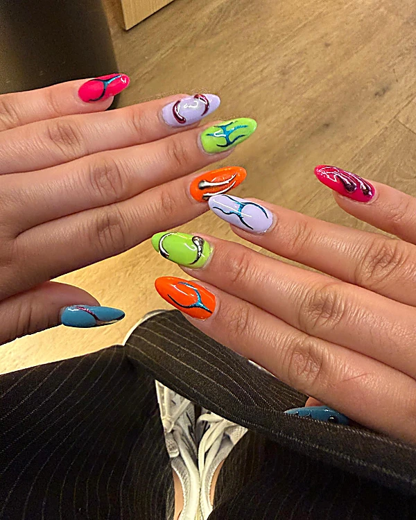 Uñas almendradas en lila, verde, naranja, rosa y azul con ondas de colores pintadas a mano